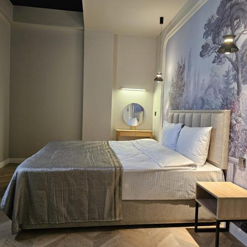 a bedroom with a bed with a painting on the wall at Luxury City Baku Apart Hotel in Baku