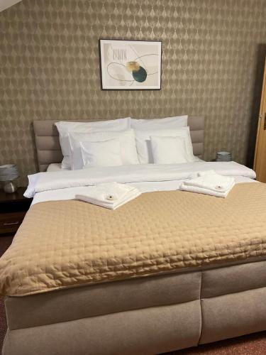 a large bed with two towels on top of it at Penzión Max Kežmarok in Kežmarok