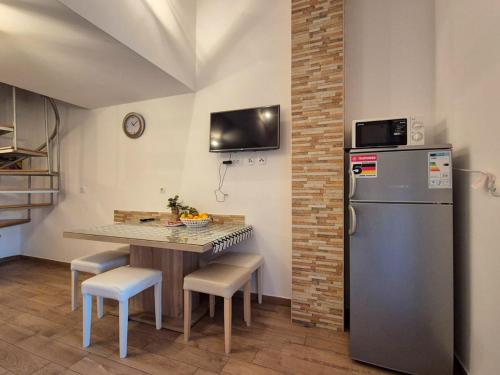 a kitchen with a refrigerator and a table with chairs at Apartman Meghan in Pula