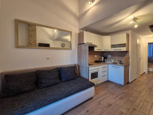 a living room with a couch and a kitchen at Apartman Meghan in Pula