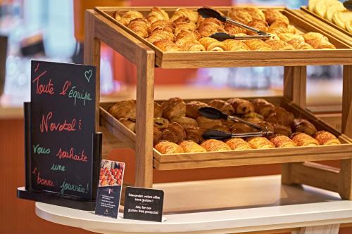 a display case filled with lots of different types of pastries at Novotel Rouen Centre Cathédrale in Rouen