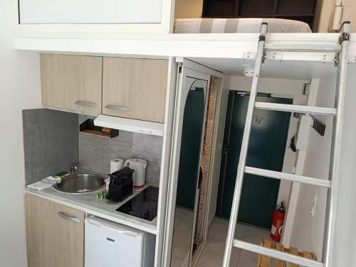 Il comprend une petite cuisine avec un évier et des lits superposés. dans l'établissement Studio climatisé, à Nice
