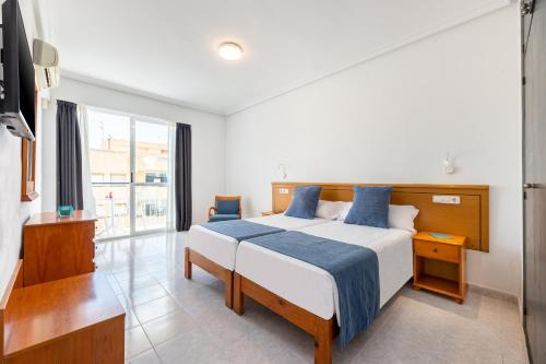 a bedroom with a bed and a large window at Hotel Vibra Vila in Ibiza Town