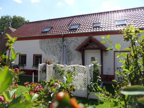 a white house with a fence in front of it at Ferienwohnung Blick zu den Sternen in Hohenbrück