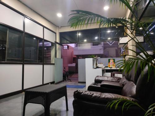 a living room with a couch and a table at Naadi stayinn -Premium Rooms in Thanjāvūr