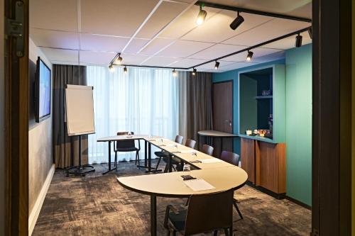 a conference room with tables and chairs and a whiteboard at Novotel Rouen Centre Cathédrale in Rouen