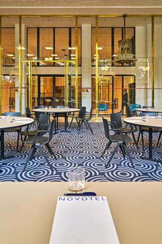 a cafeteria with tables and chairs in a building at Novotel Rouen Centre Cathédrale in Rouen