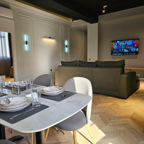 a dining room with a table and chairs and a couch at Luxury City Baku Apart Hotel in Baku