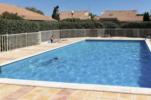 une grande piscine bleue dans une cour dans l'établissement Maison 2 pièces mezzanine - Gruissan Ayguades AY110-N02, à Narbonne-Plage