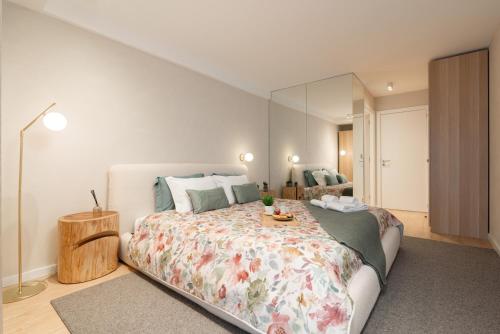 a bedroom with a large bed with a table on it at Stylish & Spacious Flat near the Beach by HostWise in Matosinhos