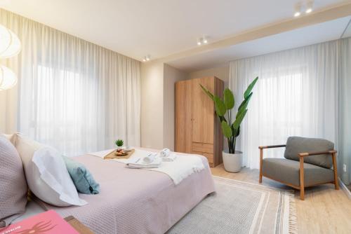 a bedroom with a bed and a chair at Stylish & Spacious Flat near the Beach by HostWise in Matosinhos