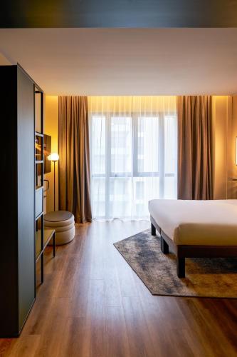 a bedroom with a bed and a large window at Novotel Rouen Centre Cathédrale in Rouen
