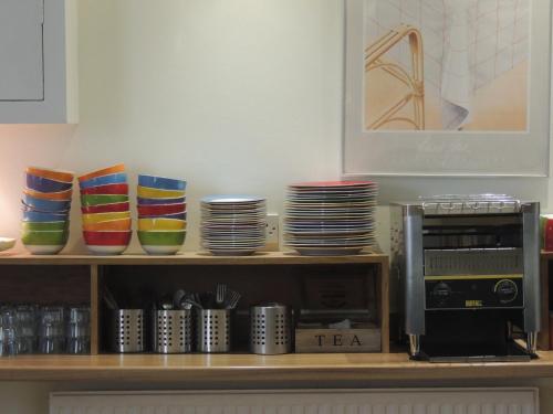 a shelf with colorful bowls and plates on it at Dolphin Inn - The Lodge in London