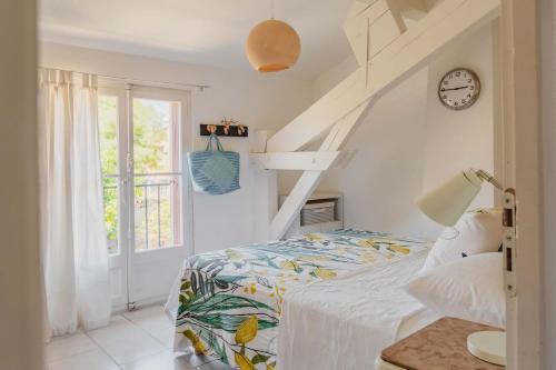 une chambre avec un lit et une horloge au mur dans l'établissement Regina's Banyuls - Asmaraloka, à Banyuls-sur-Mer