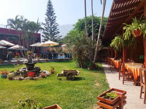 a garden with a fountain and tables and chairs at Huertalejandro Restaurante Campestre y Hospedaje in Cieneguilla