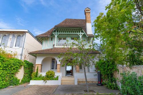 une maison blanche avec une cheminée en haut dans l'établissement Somptueuse demeure Arcachonnaise de caractère avec accès direct à la plage, à Arcachon
