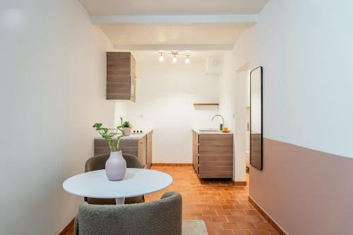 une chambre avec une table et deux chaises ainsi qu'une cuisine dans l'établissement Plein coeur historique vieille ville, à Marseille