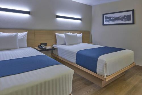 a hotel room with two beds in a room at City Express by Marriott Tijuana El Florido in Tijuana