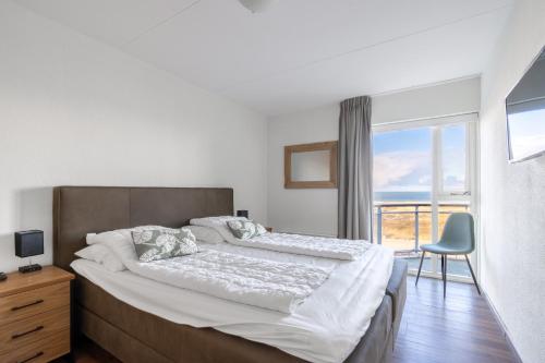 a bedroom with a large bed and a window at Appartementencomplex Juliana 166 in De Koog