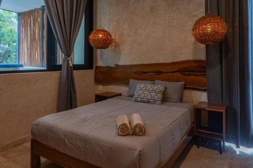 a bedroom with a bed with two towels on it at Luxury Aldea Zama 2BR Private Pool in Tulum