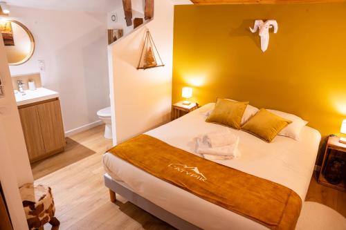 een slaapkamer met een bed met een gele muur bij Gîte Du Pré Pommier - Clim - Piscine - Sauna in Azé