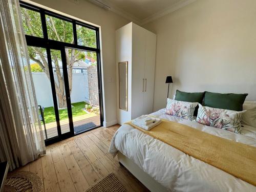 a bedroom with a large bed and a large window at Casa Montanari in Cape Town