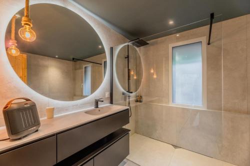 ein Badezimmer mit Waschbecken und Spiegel in der Unterkunft Villa 10pers avec piscine privée in Lacanau