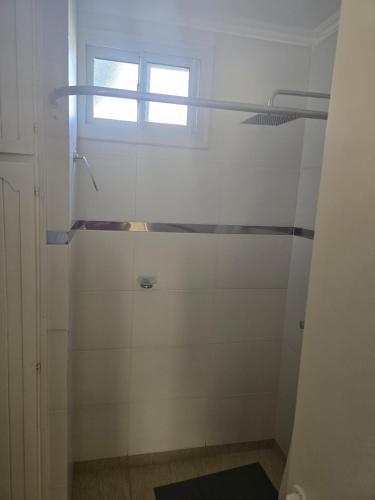 a bathroom with a shower with a window at Look Departamentos in Carhué