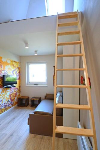 a bunk bed with a ladder in a room at Typ C2 Mini Lodge - Kalama Beach Park 2 in Pelzerhaken