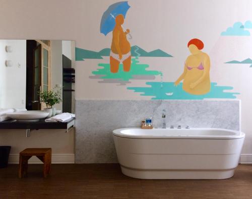 a bathroom with a bath tub and people with umbrellas at Tiszavirág Szeged in Szeged