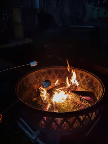 a grill with fire inside of it with a stick at Huertalejandro Restaurante Campestre y Hospedaje in Cieneguilla