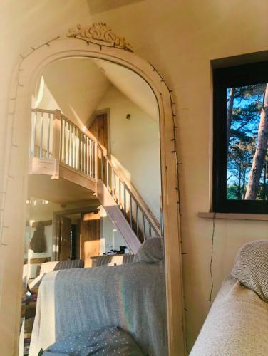 a mirror in a living room with a staircase at Toad Hall in Grimston