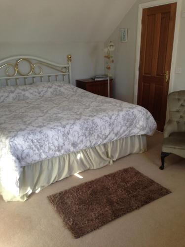 a bedroom with a bed and a chair and a rug at Rebels Hide -Self check in rooms in Penrith