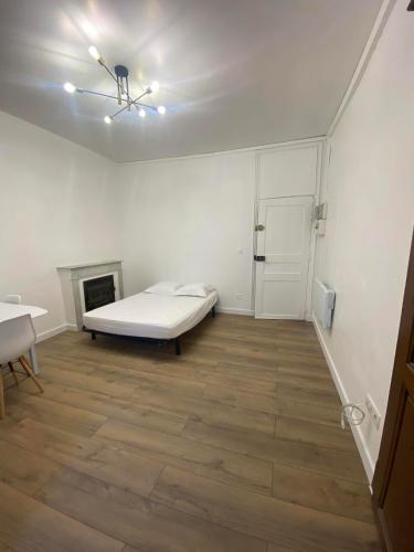 Cette chambre blanche dispose d'un lit et d'une cheminée. dans l'établissement Charmant studio en centre-ville, à Corte