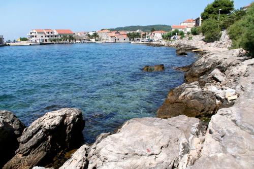 a body of water with rocks in the foreground at Apartments by the sea Sucuraj, Hvar - 578 in Sućuraj