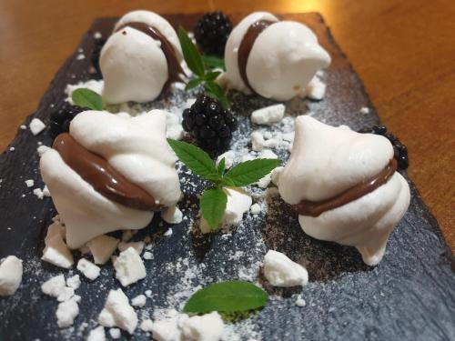 a dessert with chocolate and blackberries on a black plate at Agriturismo La.Ti.Mi.Da. in Cassine