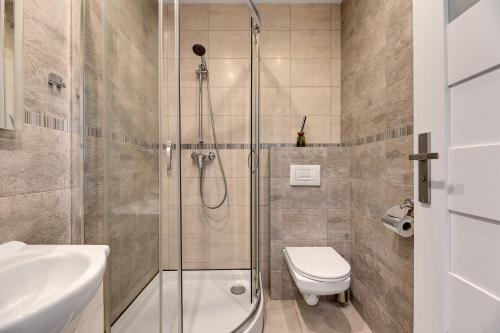a bathroom with a shower and a toilet and a sink at Sopot Host Patio in Sopot