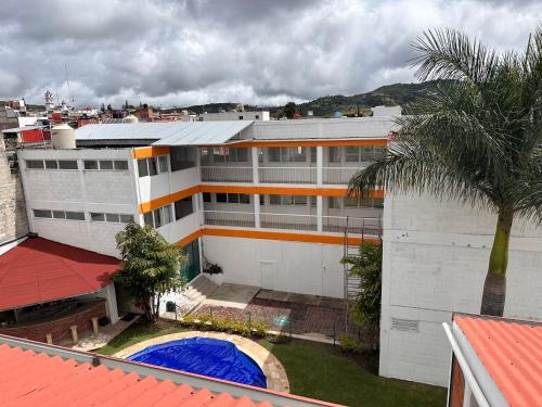 a building with a swimming pool in front of it at Hotel El Romano in Ixtapan de la Sal