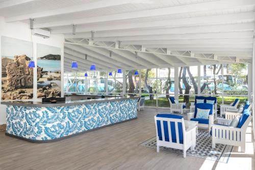 un vestíbulo con un bar con sillas azules y blancas en Aparthotel Vibra Club Maritim, en Bahía de San Antonio