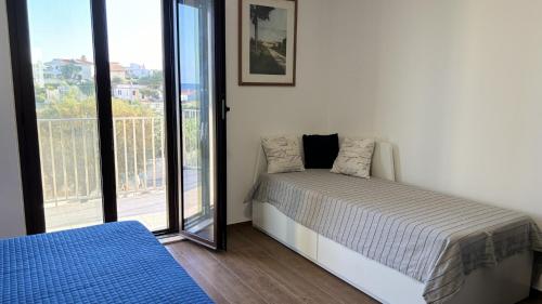 a white bedroom with a bed and a window at Villa sapore di mare con con spazio privato in spiaggia in San Lorenzo