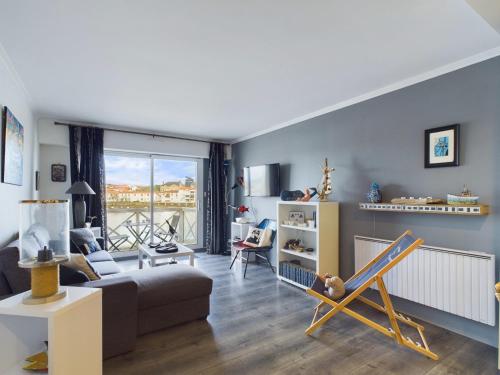 un salon avec un canapé et une chaise dans l'établissement Appartement cosy pour 4, vue sur la Vie, à Saint-Gilles-Croix-de-Vie