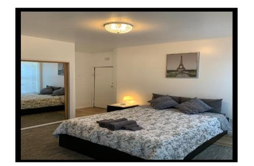 a bedroom with a large bed with a lamp and a picture at Magnolia Stay near New York City in Jersey City