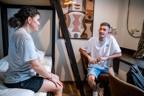 a man sitting on a bed talking to a woman at Jungle House in Las Palmas de Gran Canaria