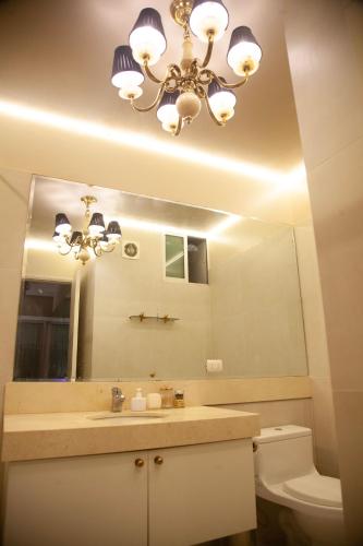 a bathroom with a large mirror and a chandelier at Chic Miraflores AC HEATER 16th floor in Lima