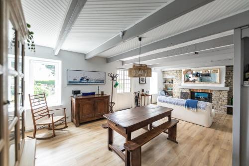 un salon avec une table et une cheminée dans l'établissement 50 m de la plage - Maison pour 6 avec jardin, à Tréffiagat