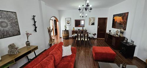 a living room with a red couch and a table at Casa V del Pino in Teror