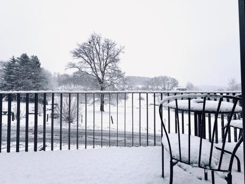 ein mit Schnee bedeckter Zaun neben einer Bank in der Unterkunft FeWo Anders - Neubau mit Balkon im Bergischen Land in Reichshof 