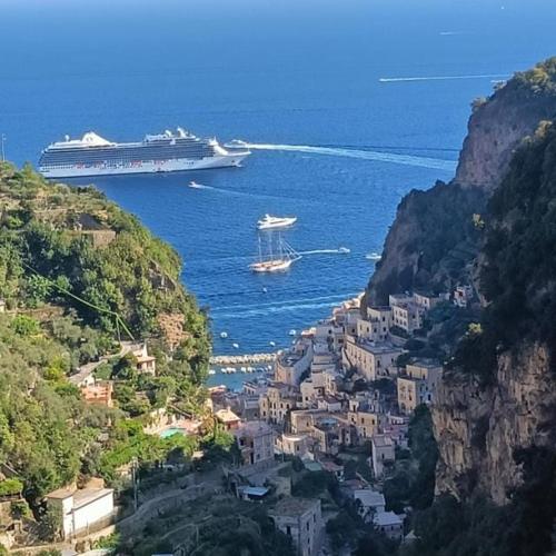a cruise ship in the ocean next to a city at Terrace Belvedere suite- Amalfi coast - free park- Pontone -Scala in Pontone