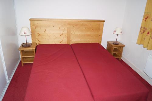 - une chambre avec un lit rouge et deux lampes dans l'établissement Bel appart T2, 3 étoiles, avec balcon bien exposé, à Vielle-Aure