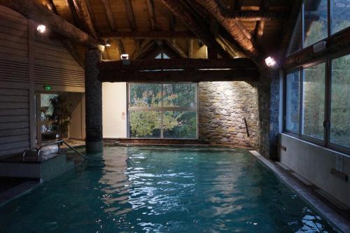 une piscine dans un immeuble avec une grande fenêtre dans l'établissement Bel appart T2, 3 étoiles, avec balcon bien exposé, à Vielle-Aure